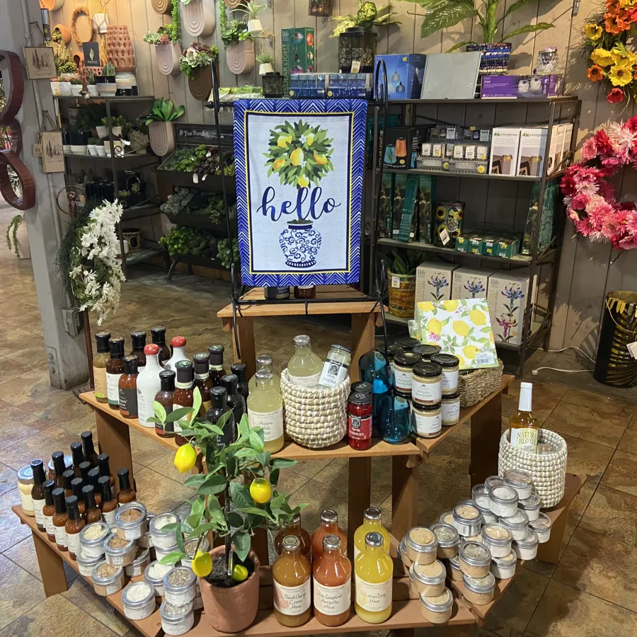 Display of citrus-themed home decor items, skincare products, and floral wreaths in a store setting.