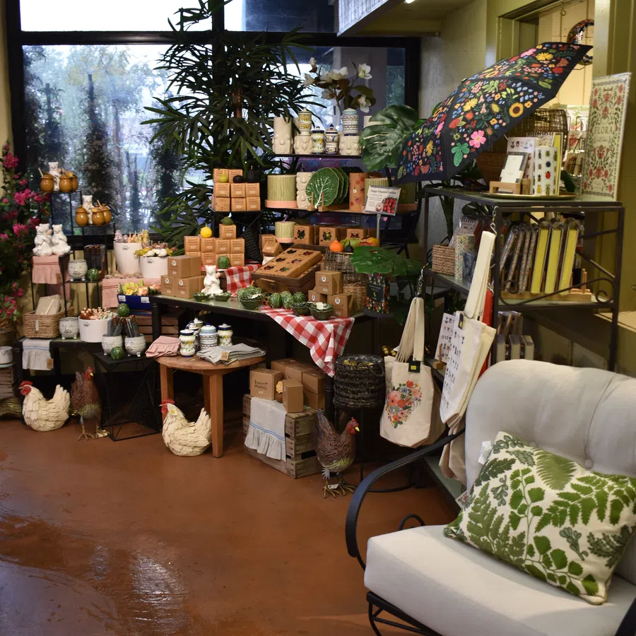 Cozy indoor display of decorative plants, ceramic chickens, tableware, and floral-themed home decor items.