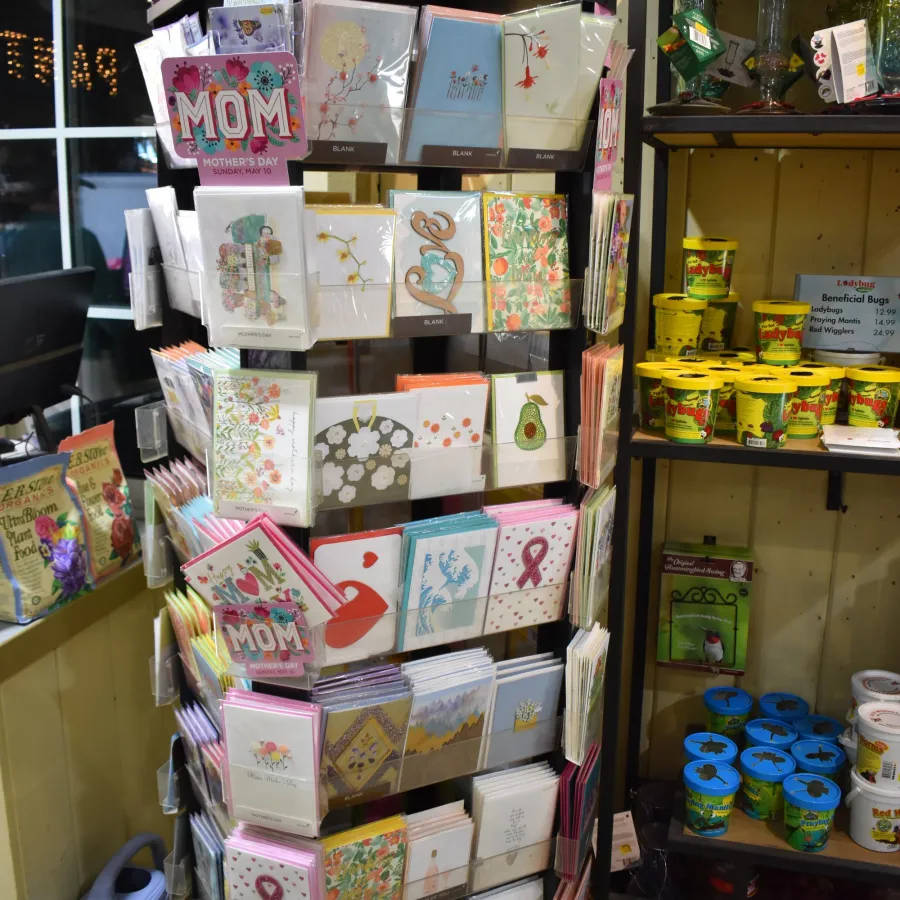 Mother's Day greeting cards on display rack in a store with floral and heart designs