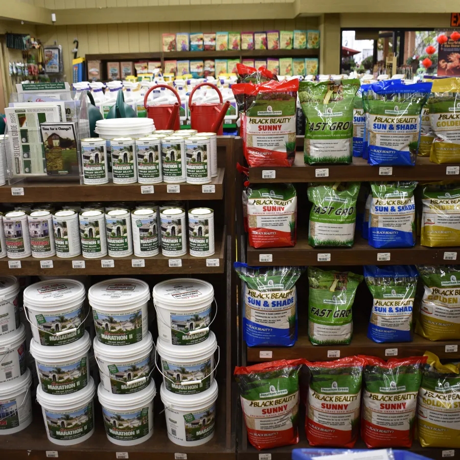 Shelves stocked with various gardening products including plant fertilizers, soil, and gardening supplies in a store.