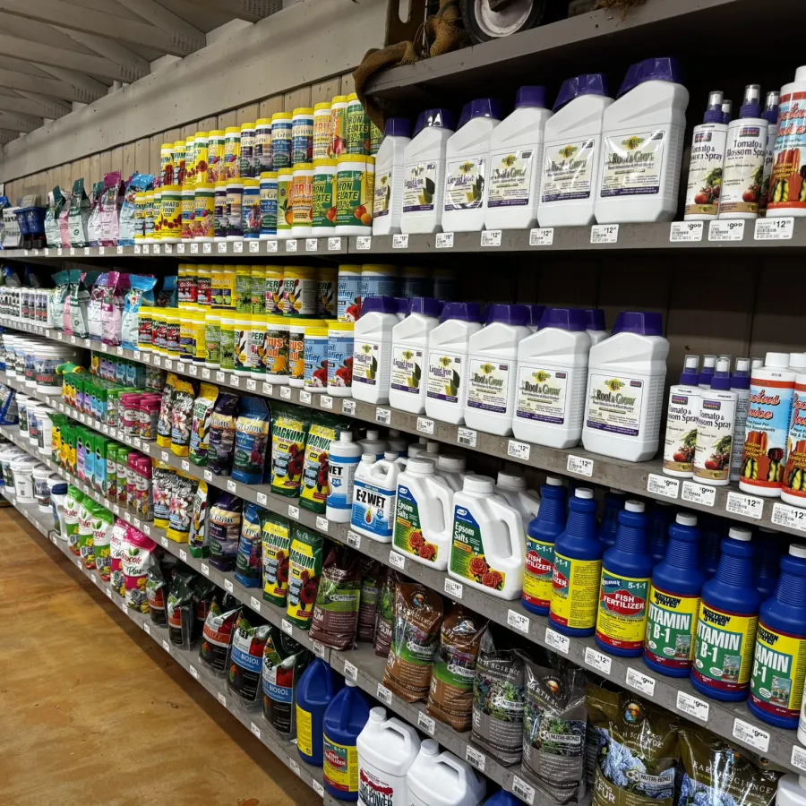 Store aisle filled with shelves displaying various colorful gardening fertilizers and plant care products.