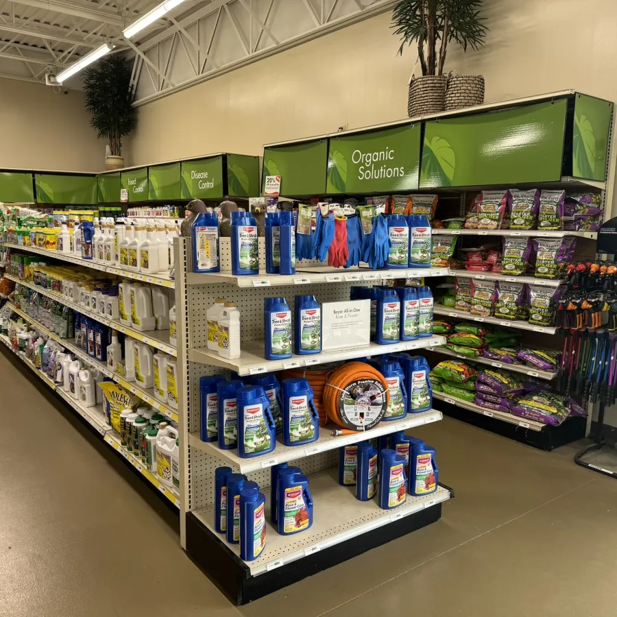 Aisle in garden store featuring organic solutions, disease control, tools, and gardening supplies on shelves.