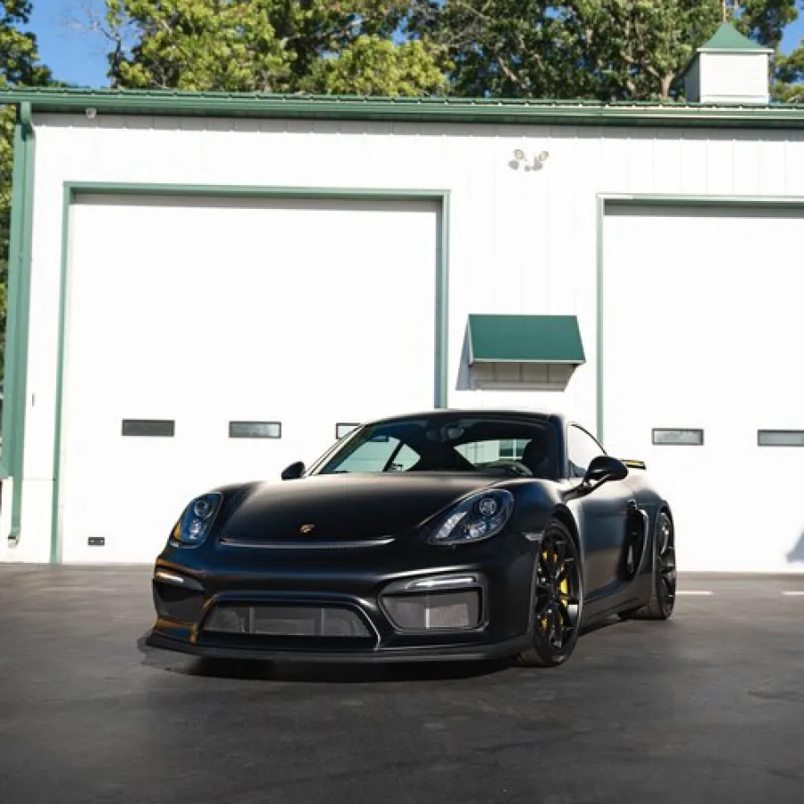 a black sports car parked in front of a garage