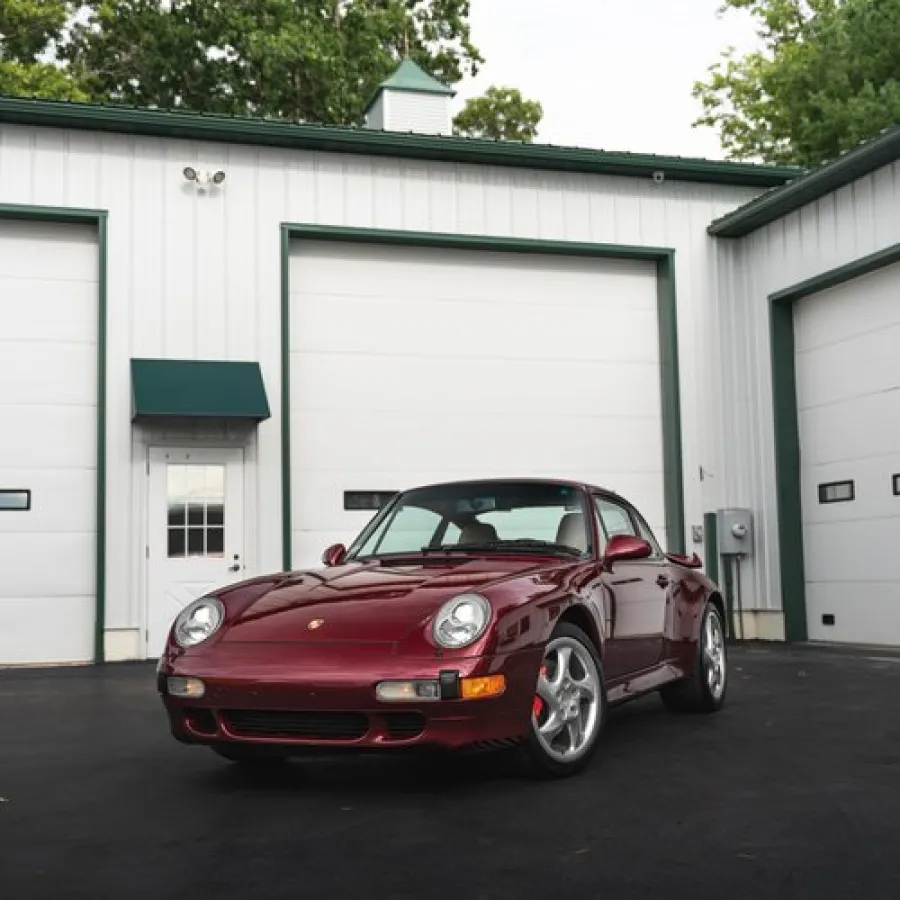 a red car parked in front of a garage