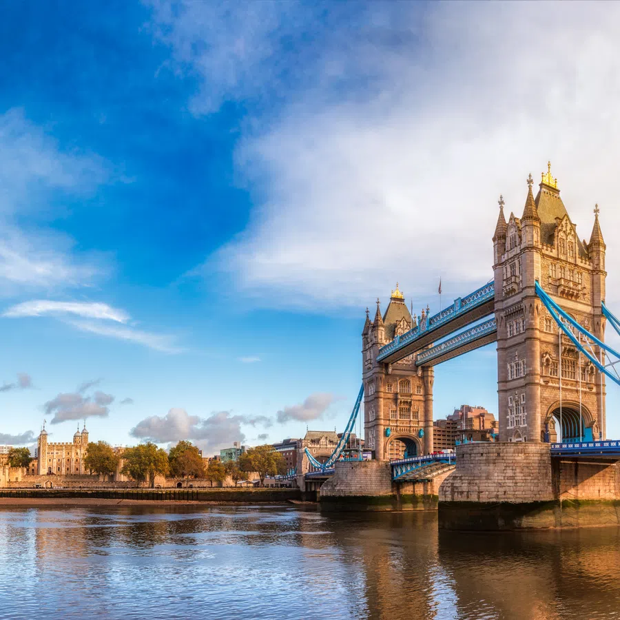 Tower Bridge in London over the River Thames on a clear day with city skyline and blue sky.