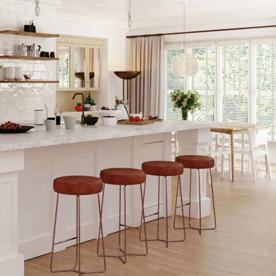 Modern kitchen island with white marble countertop and four brown leather bar stools in spacious dining area.