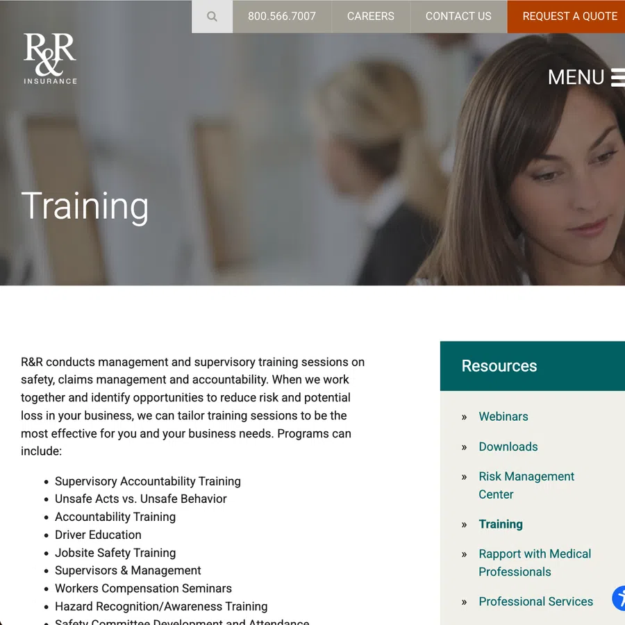 Woman focusing on training session content with blurred colleagues in background on insurance website.