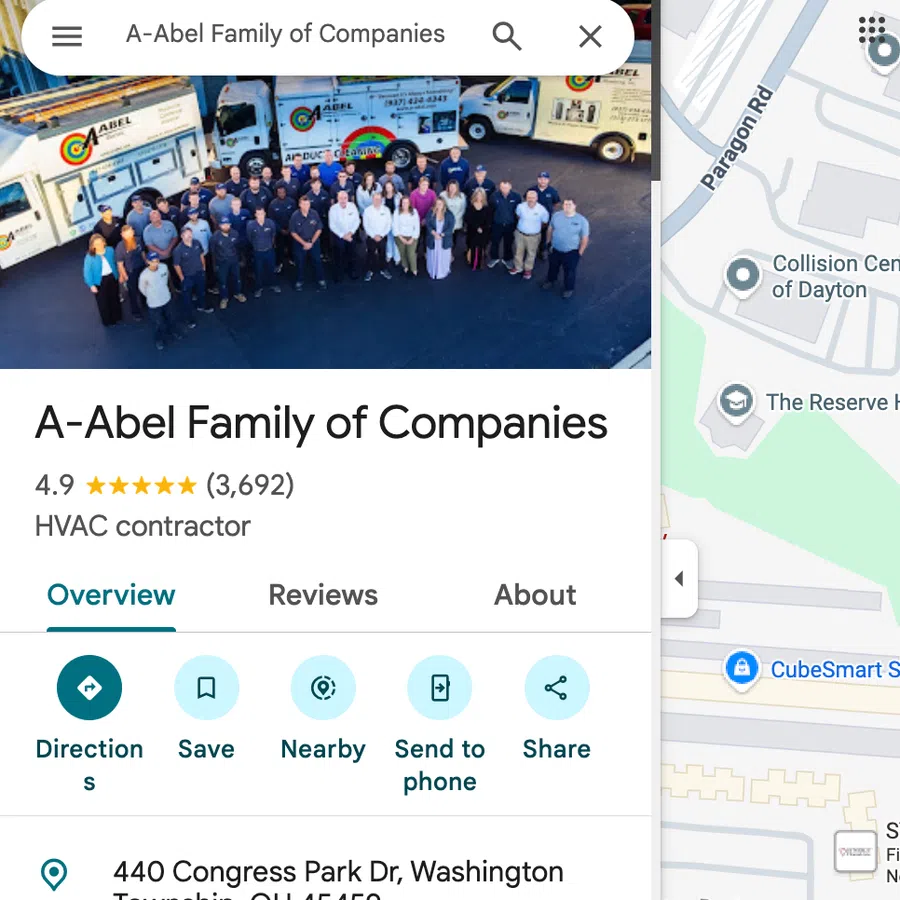 Group photo of A-Abel Family of Companies employees standing in front of company-branded service trucks.