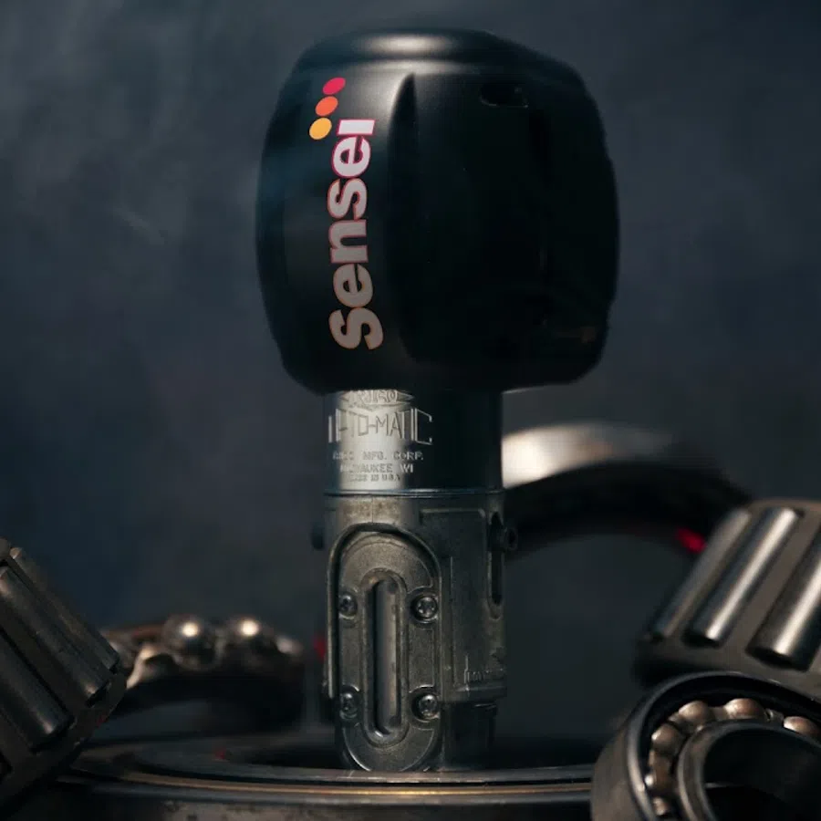 Sensei tattoo machine motor surrounded by metallic bearings with smoky dark background atmosphere