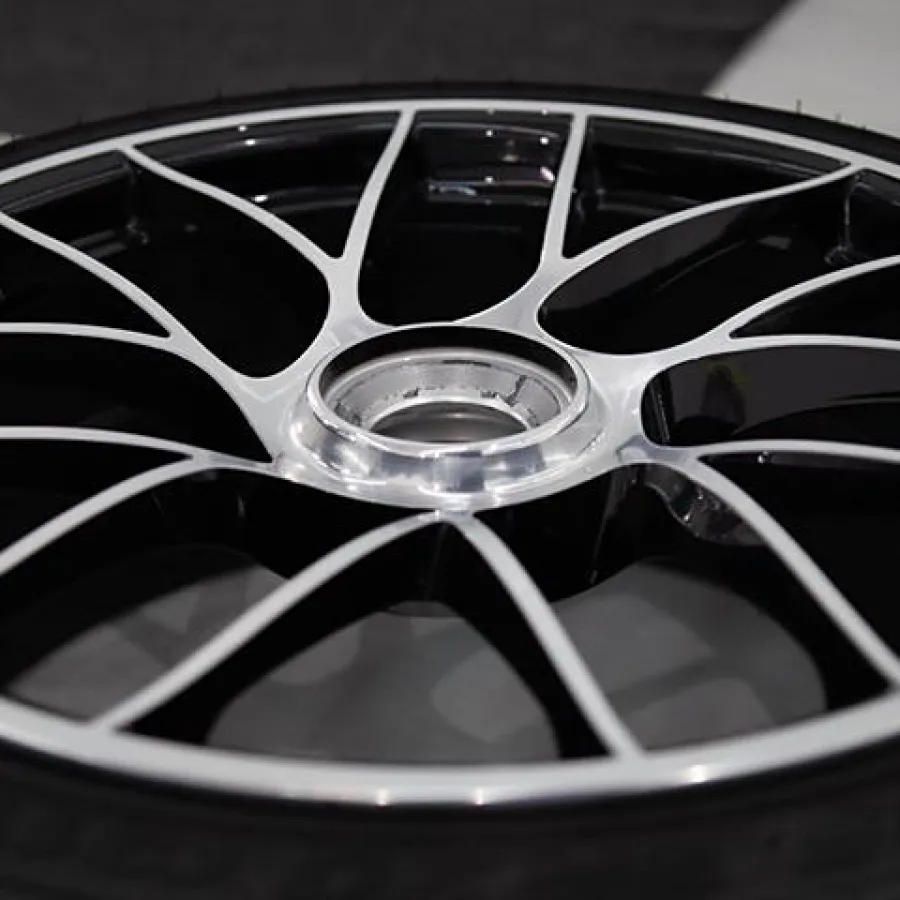Close-up of a sleek black and silver car wheel rim with thin spokes on a high-performance tire.