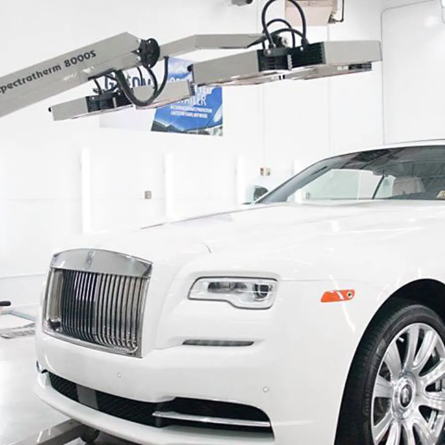 White luxury Rolls-Royce car on a blue platform undergoing body inspection with Spectratek 8000S scanner in a workshop.