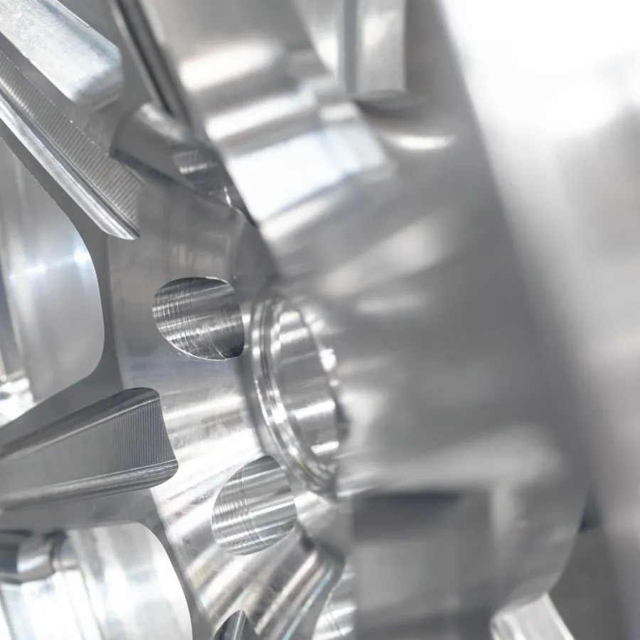 Close-up of shiny silver metal gear with precision-cut teeth and reflective surface in industrial setting