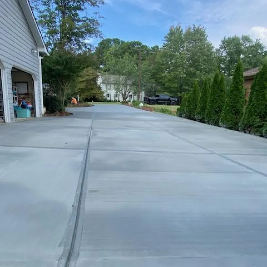 a driveway with a car parked in the background