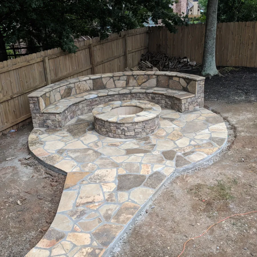 Walking path leading to circular fire pit slab with built-in seating