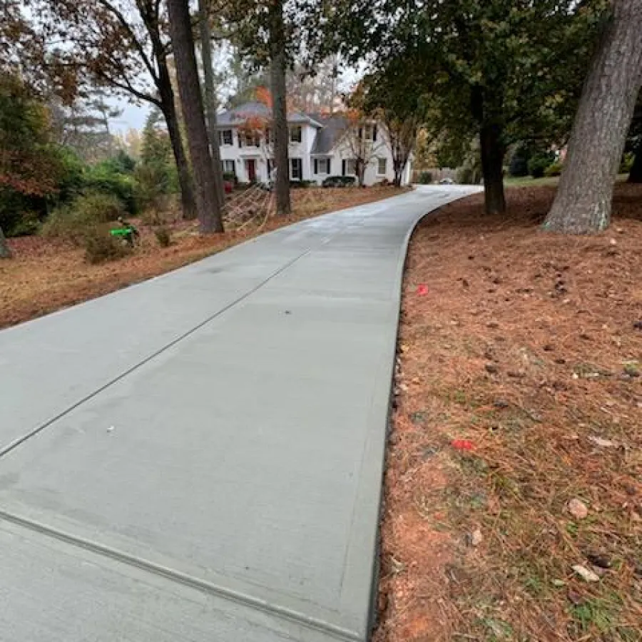 a sidewalk with trees and grass