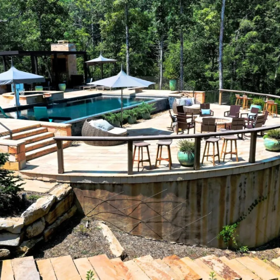 a pool with chairs and tables next to it