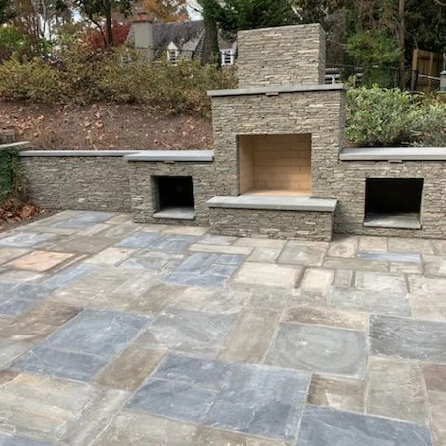 a stone patio with a stone fireplace