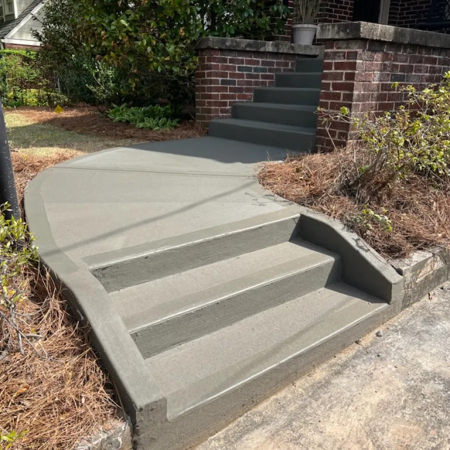Freshly poured concrete steps with curved pathway surrounded by greenery.