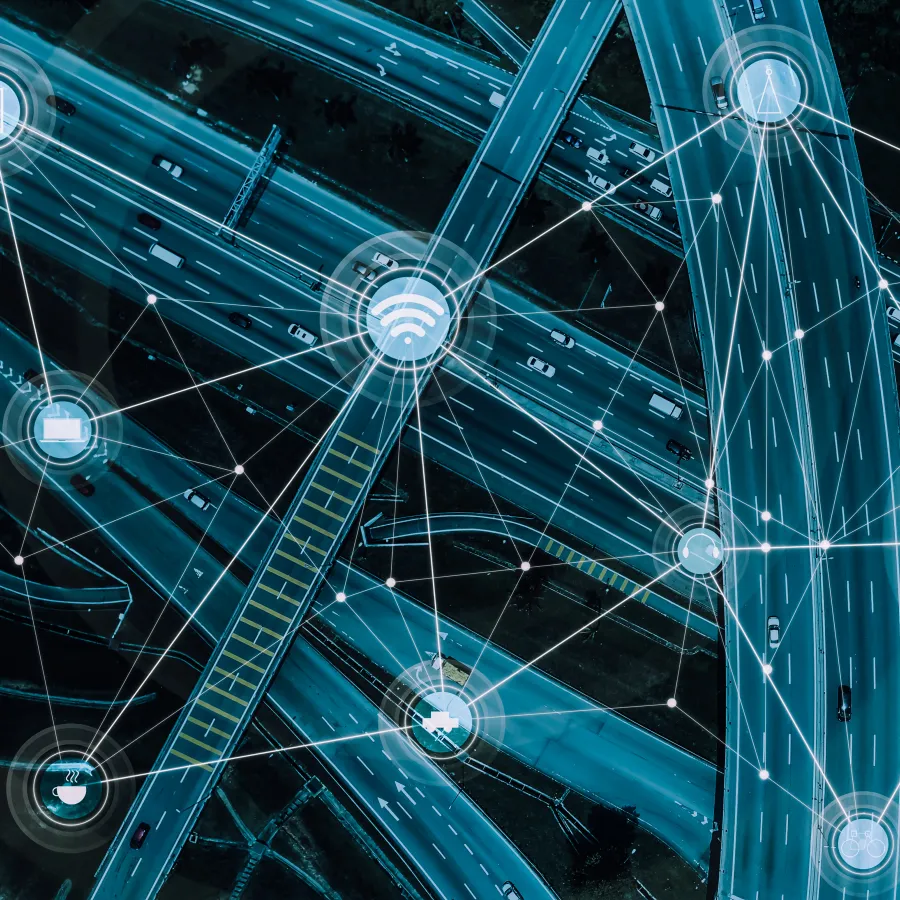 Aerial view of a complex highway network with digital connectivity icons overlaid.