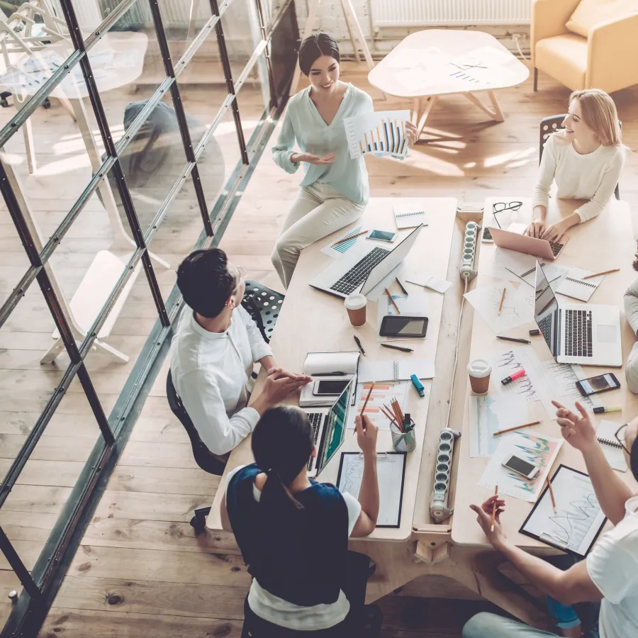 A diverse team collaborating in a modern office, discussing ideas around a large table.