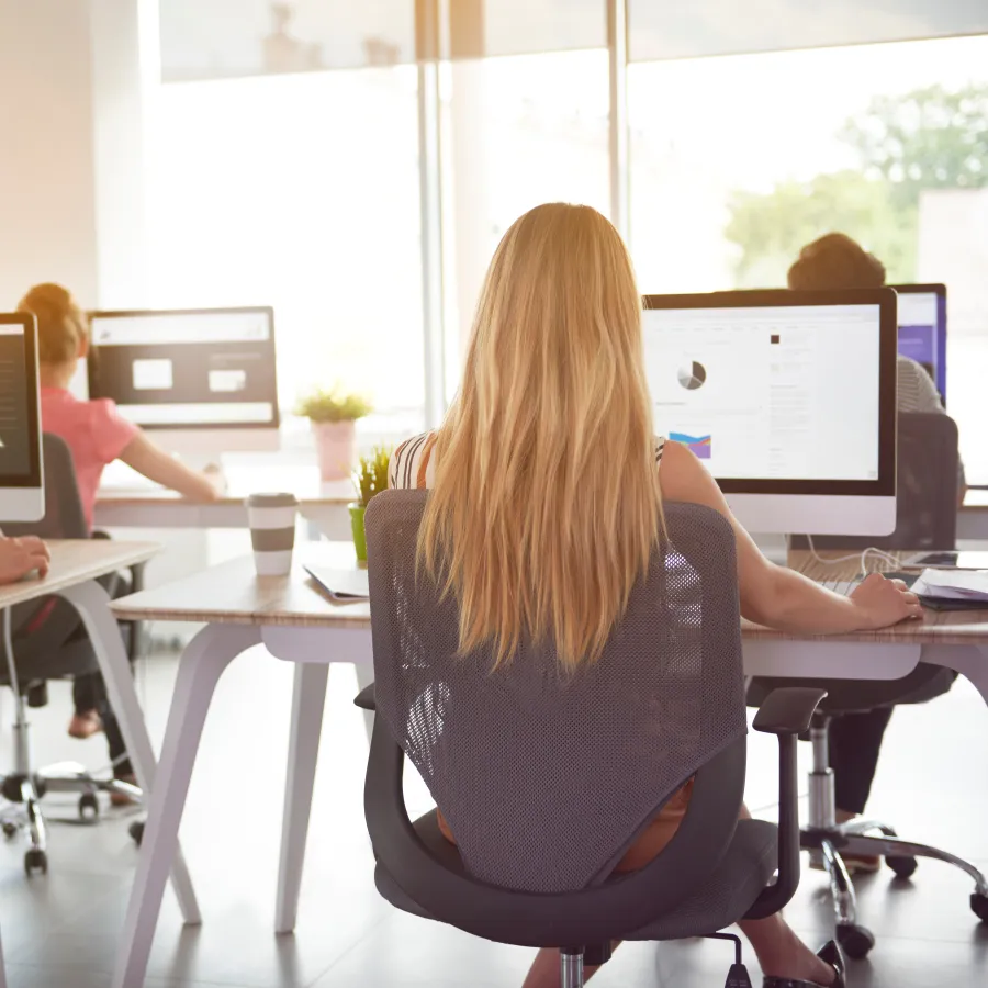 a group of people sitting at a table with computers
