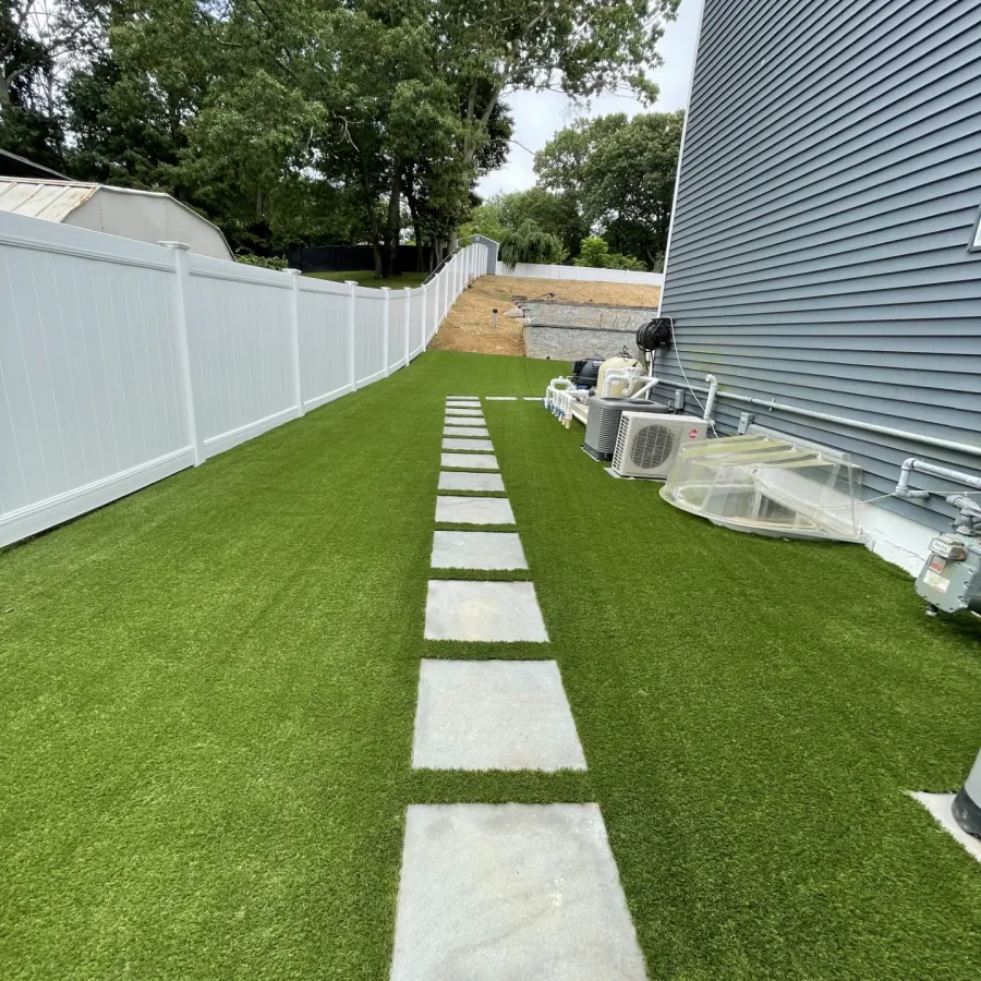 a green lawn with a white fence