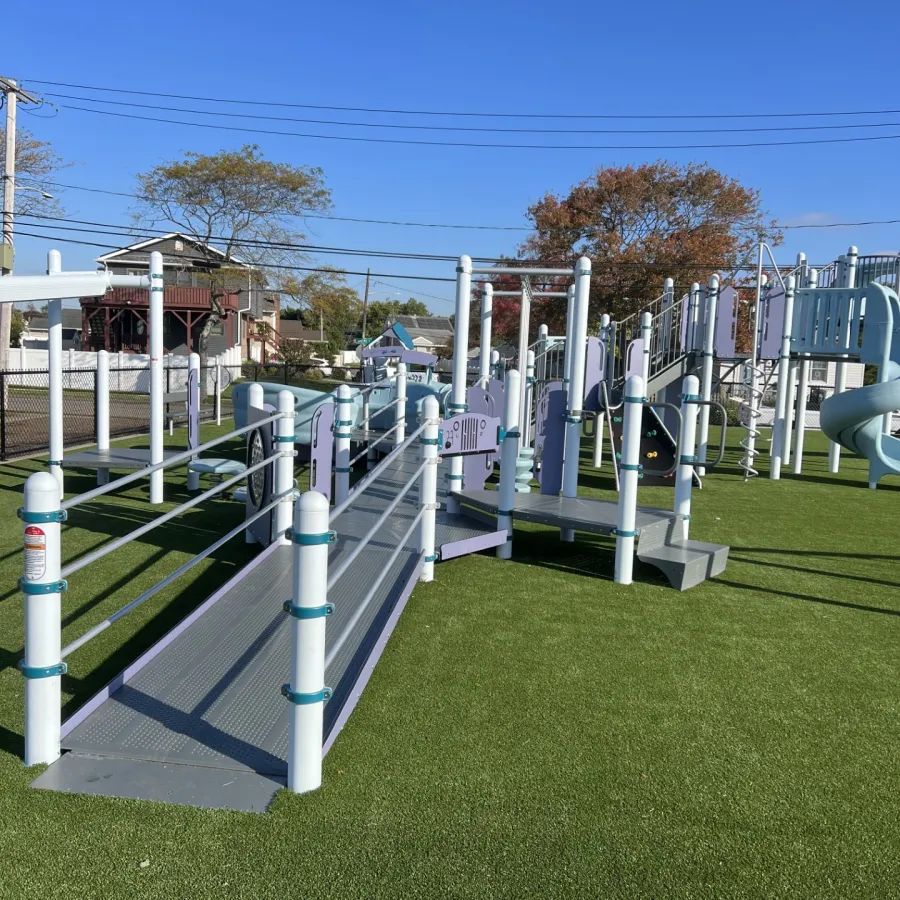 a row of white poles in a grassy area
