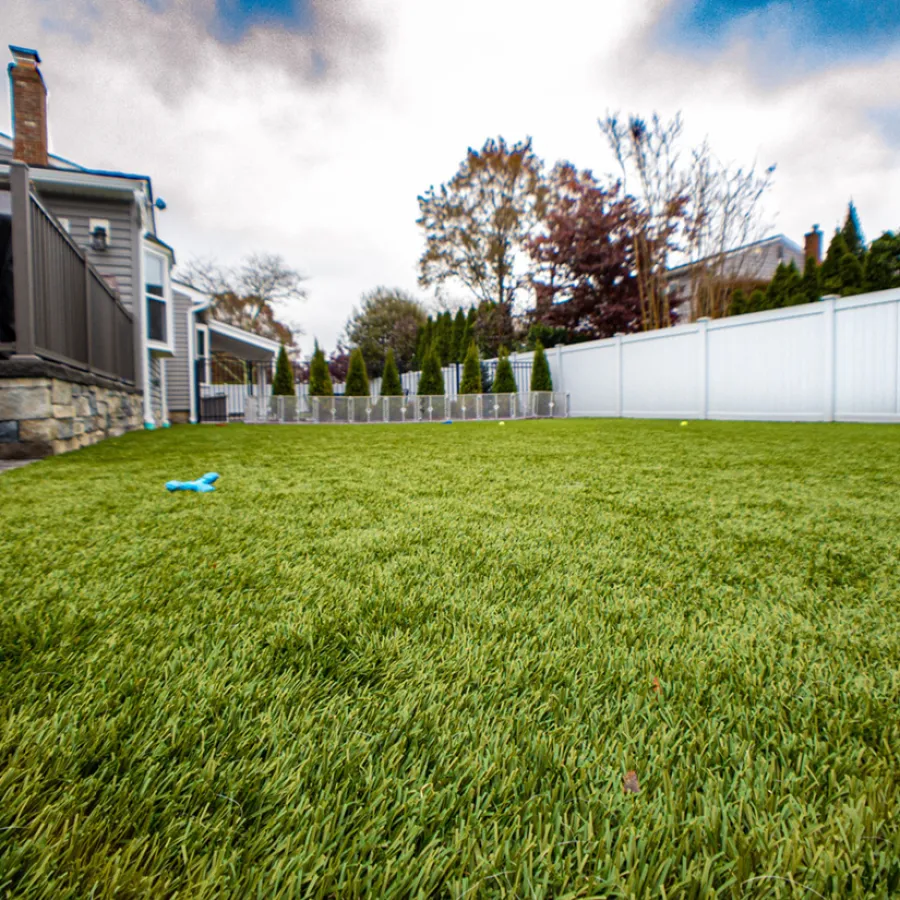 a yard with a white fence and a house with a white picket fence