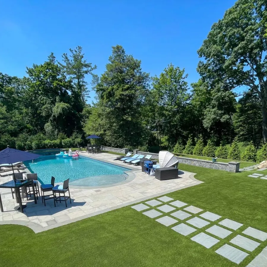a pool with a patio and chairs