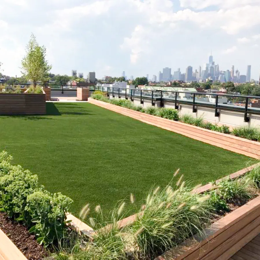 a large green field with a city in the background