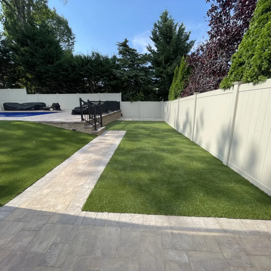 a backyard with a fence and a lawn