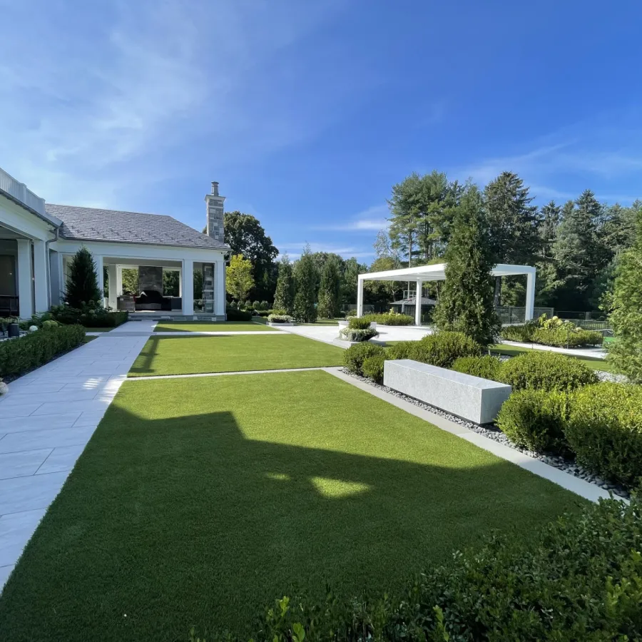 a large green lawn with a house in the background