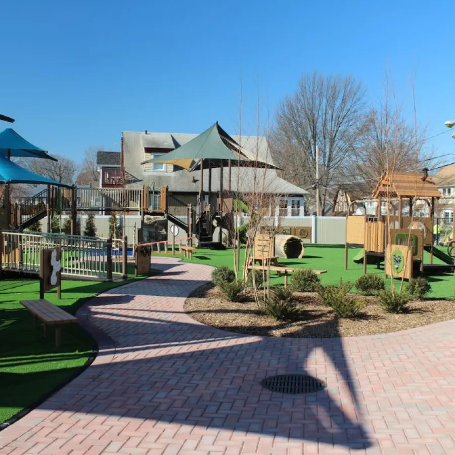 a brick walkway with a brick walkway and a fence and a building