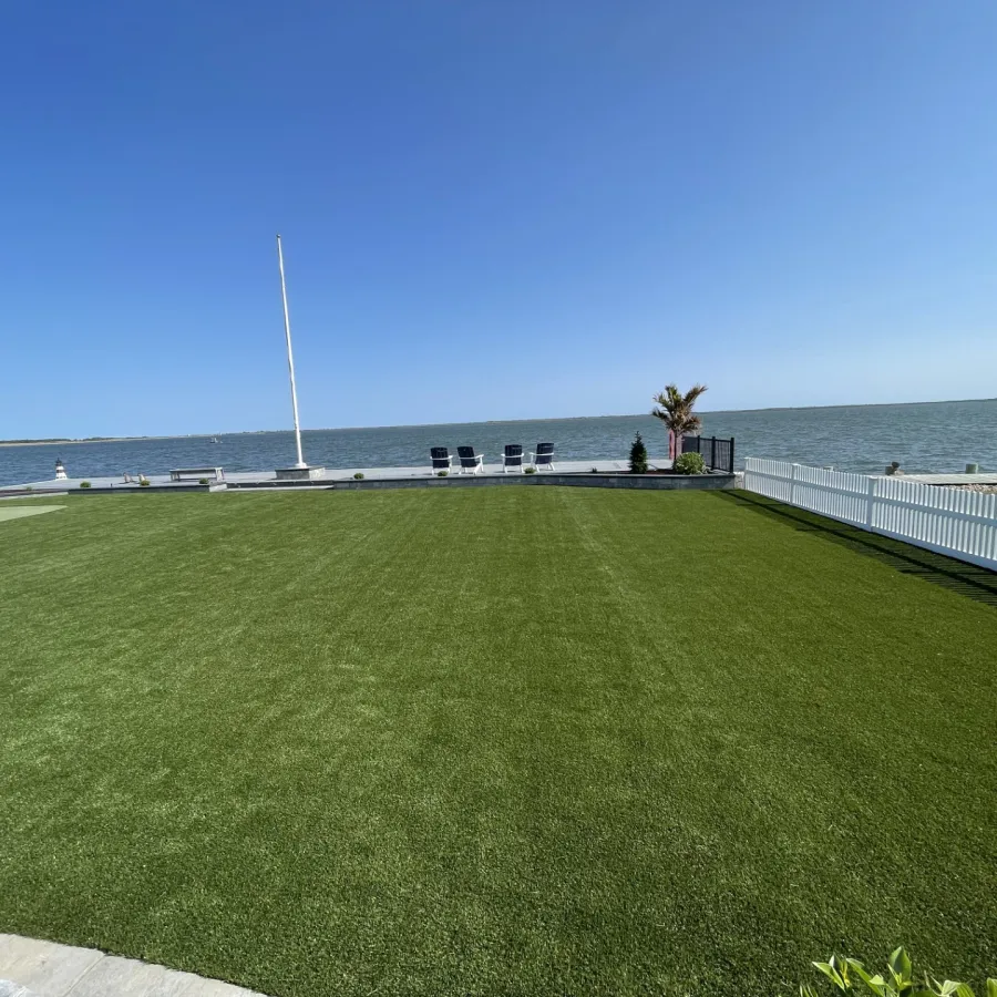 a grassy area with a body of water in the background