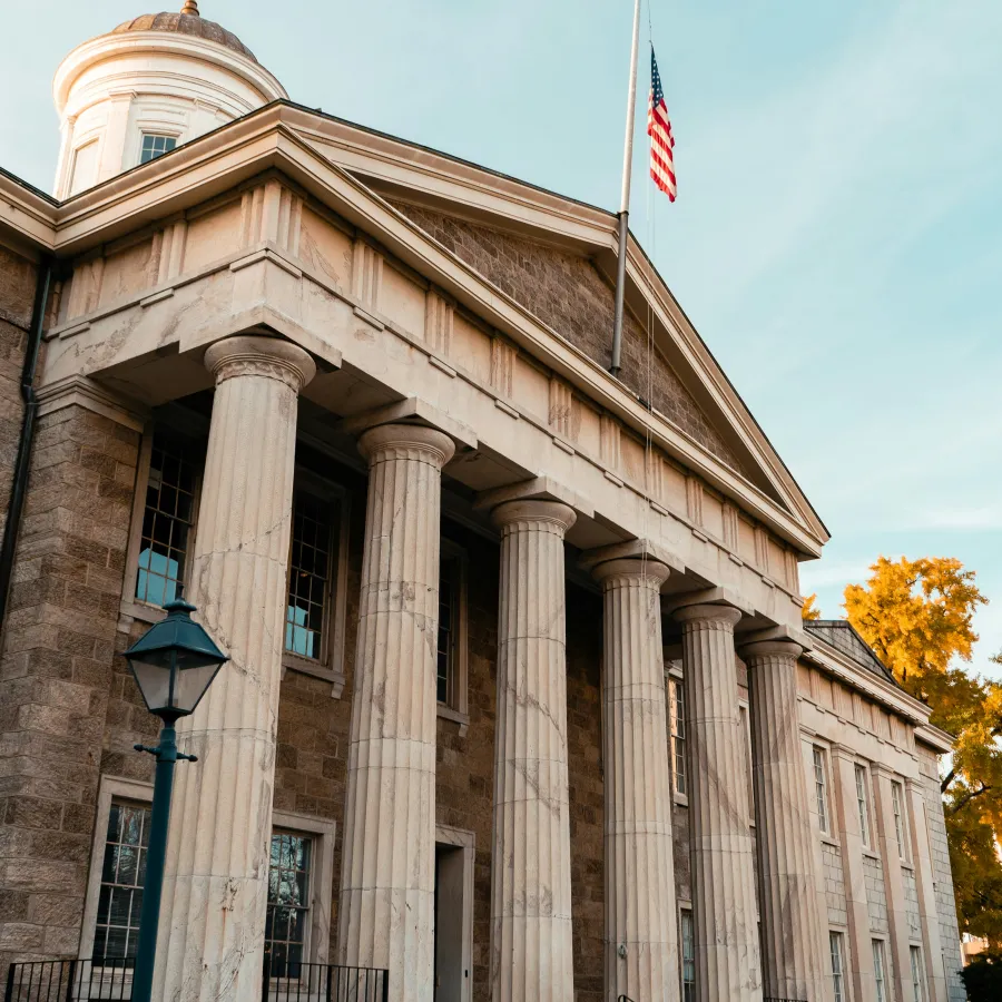 a building with columns and a flag on top