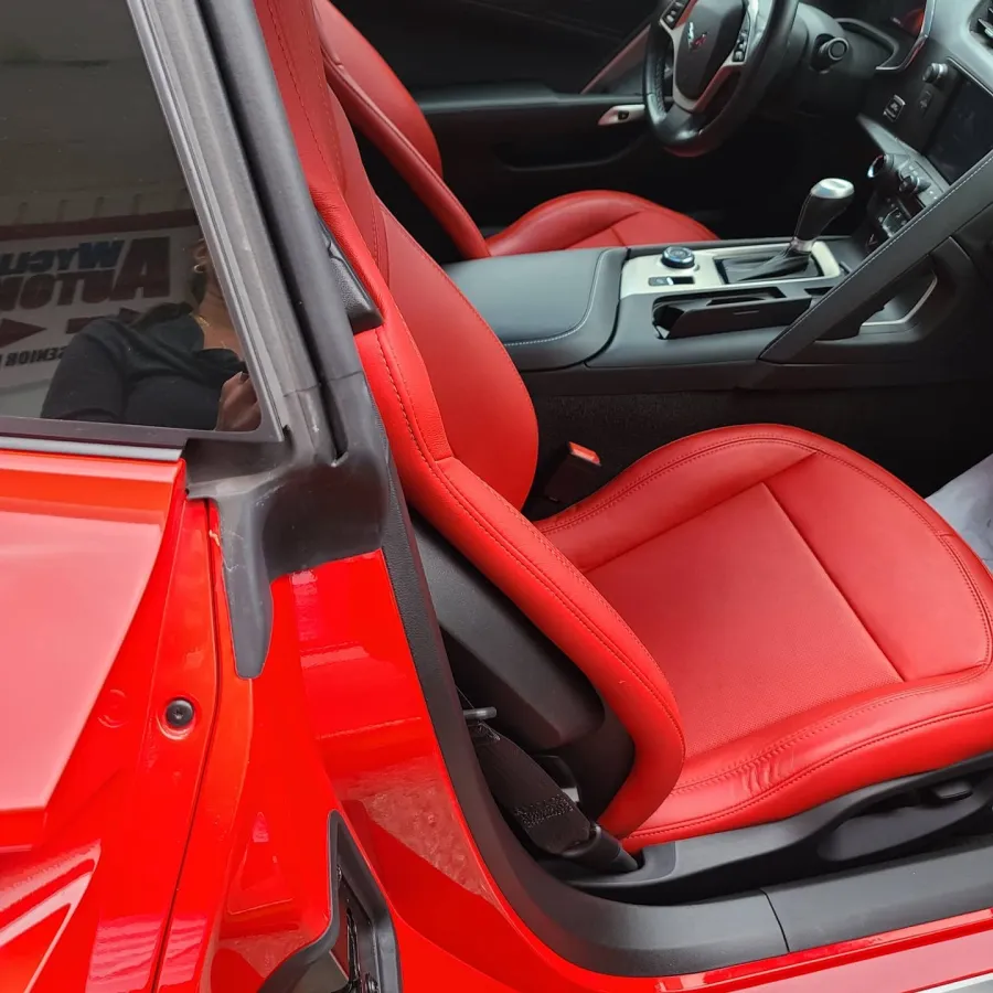 Close-up of a car interior featuring vibrant red leather seats and a sleek center console with gear shift.