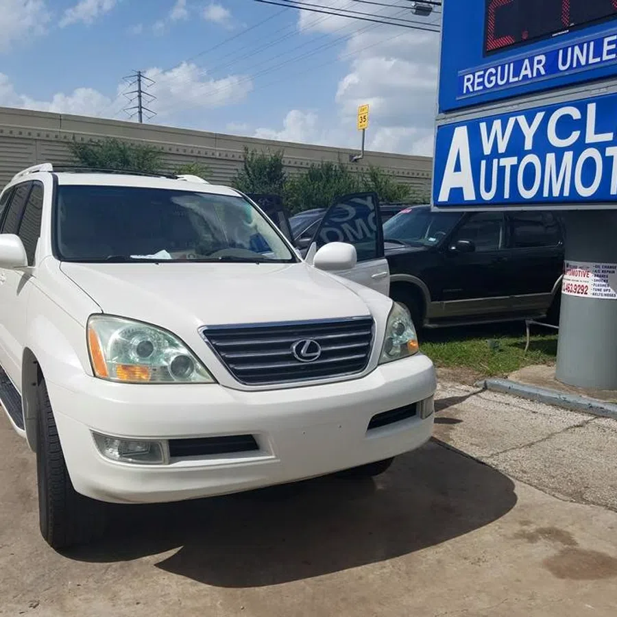 White Lexus SUV parked near Wycliff Automotive sign on a sunny day in a service lot