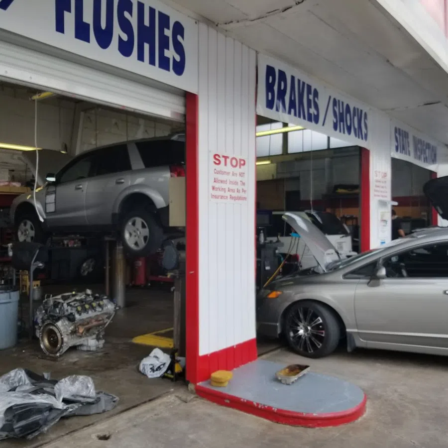 Auto repair shop with cars being serviced, one lifted and another with hood open for maintenance.