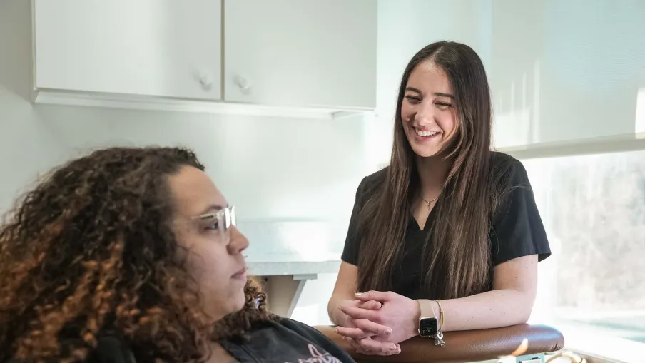 Smiling healthcare professional talking with a patient in a bright medical office during consultation.