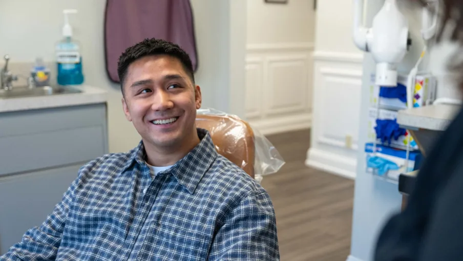 Smiling man sitting in dental chair during appointment in a modern dental office