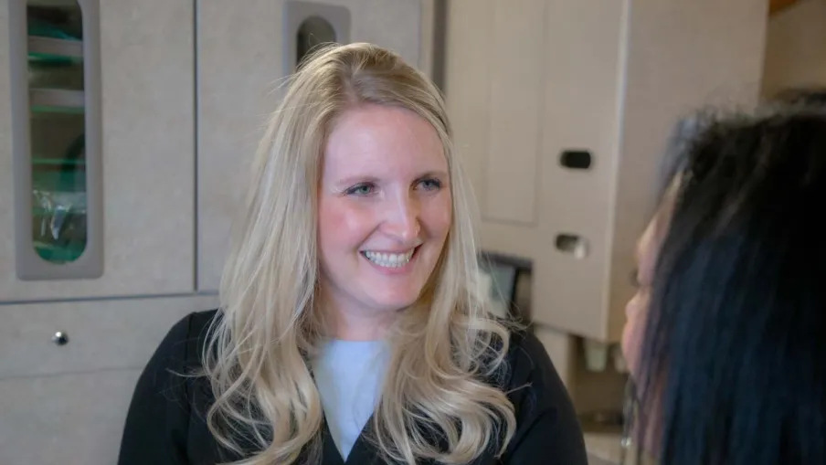 Smiling blonde female healthcare professional talking to a patient in a medical clinic setting