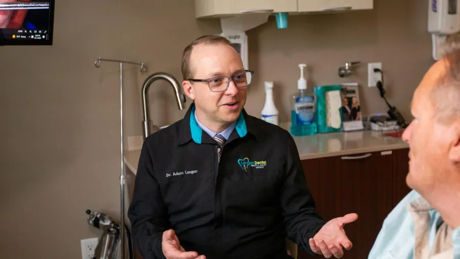 Dentist consulting with a patient in a modern dental office, showcasing a friendly atmosphere.
