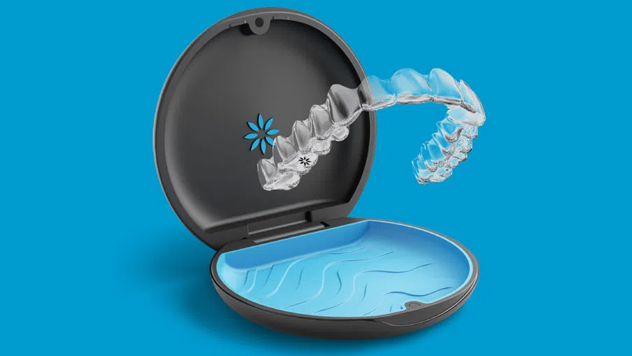 Clear dental aligner hovering above open black and blue carrying case on a blue background