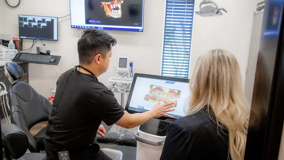 Dentist showing digital dental scan images to a patient in a modern dental office with advanced technology.