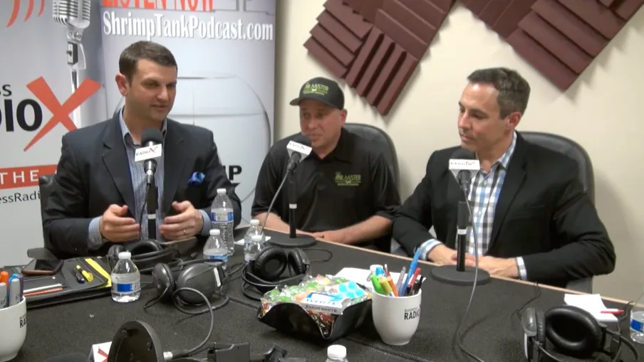 a group of men sitting at a table with microphones