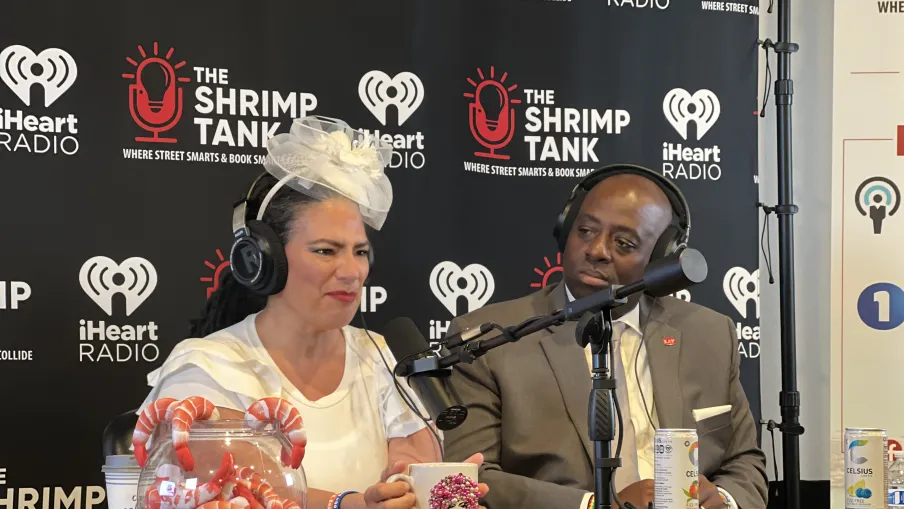 a man and woman sitting at a table with microphones
