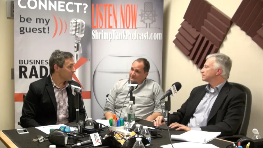a group of men sitting at a table with microphones