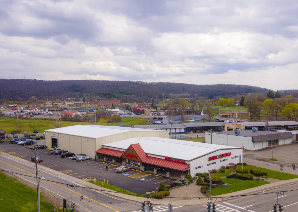 Aerial view of a Lowe's home improvement store with parking lot and surrounding roads under a cloudy sky.