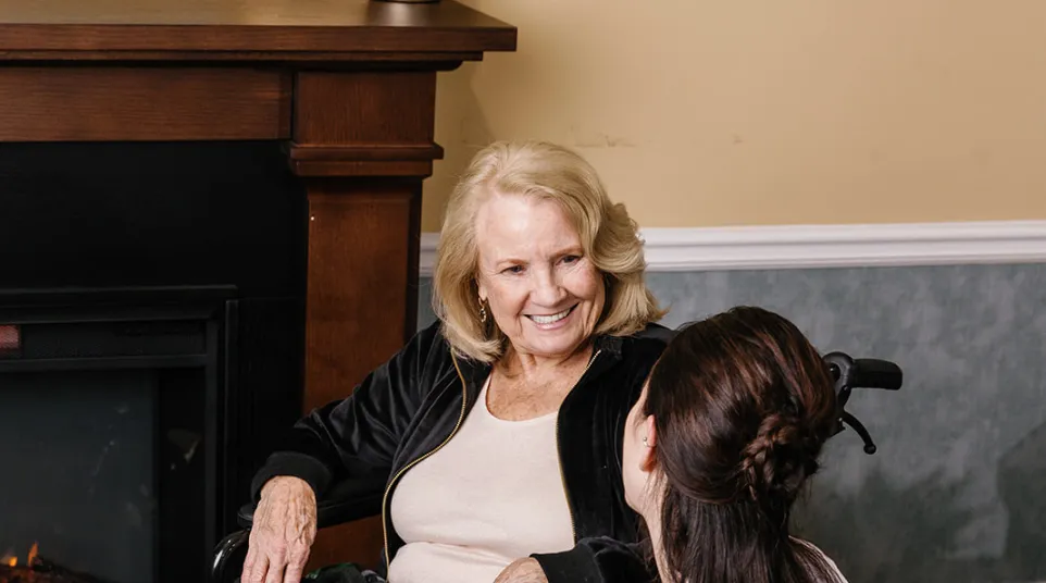 a person sitting on another woman's lap