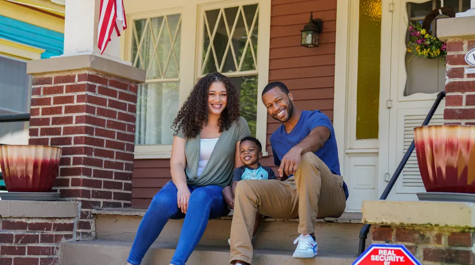 a family sitting on a porch with a child